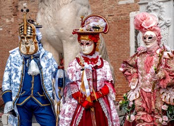 People in costume at the Venice Carnival in front of the Venetian Arsenal.