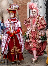 People in costume at the Venice Carnival in front of the Venetian Arsenal.