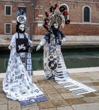 People in costume at the Venice Carnival in front of the Venetian Arsenal.