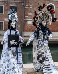 People in costume at the Venice Carnival in front of the Venetian Arsenal.