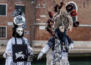 People in costume at the Venice Carnival in front of the Venetian Arsenal.