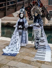 People in costume at the Venice Carnival in front of the Venetian Arsenal.