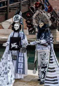 People in costume at the Venice Carnival in front of the Venetian Arsenal.