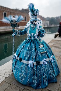 People in costume at the Venice Carnival in front of the Venetian Arsenal.