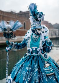 People in costume at the Venice Carnival in front of the Venetian Arsenal.