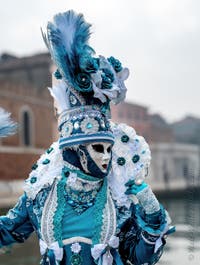 People in costume at the Venice Carnival in front of the Venetian Arsenal.