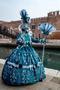 People in costume at the Venice Carnival in front of the Venetian Arsenal.