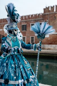 People in costume at the Venice Carnival in front of the Venetian Arsenal.