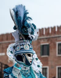 People in costume at the Venice Carnival in front of the Venetian Arsenal.