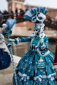 People in costume at the Venice Carnival in front of the Venetian Arsenal.