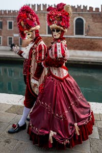 People in costume at the Venice Carnival in front of the Venetian Arsenal.