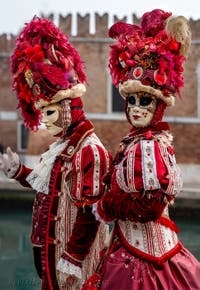 People in costume at the Venice Carnival in front of the Venetian Arsenal.