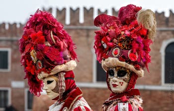 People in costume at the Venice Carnival in front of the Venetian Arsenal.