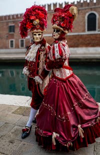 People in costume at the Venice Carnival in front of the Venetian Arsenal.