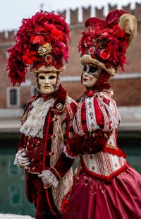 People in costume at the Venice Carnival in front of the Venetian Arsenal.