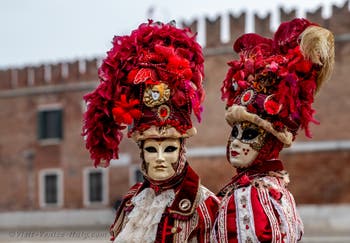 People in costume at the Venice Carnival in front of the Venetian Arsenal.