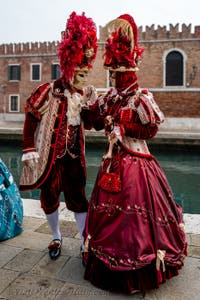 People in costume at the Venice Carnival in front of the Venetian Arsenal.