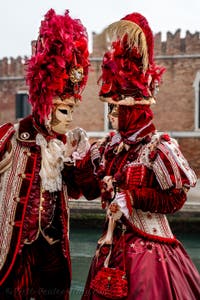 People in costume at the Venice Carnival in front of the Venetian Arsenal.