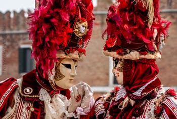 People in costume at the Venice Carnival in front of the Venetian Arsenal.