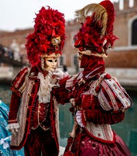 People in costume at the Venice Carnival in front of the Venetian Arsenal.