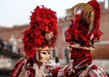 People in costume at the Venice Carnival in front of the Venetian Arsenal.