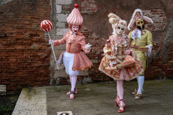 People in costume at the Venice Carnival in front of the Venetian Arsenal.