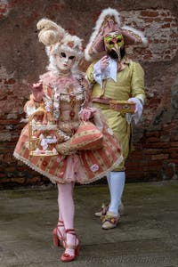 People in costume at the Venice Carnival in front of the Venetian Arsenal.