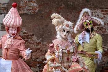 People in costume at the Venice Carnival in front of the Venetian Arsenal.