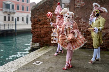 People in costume at the Venice Carnival in front of the Venetian Arsenal.