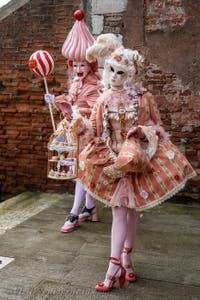 People in costume at the Venice Carnival in front of the Venetian Arsenal.