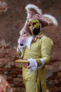 People in costume at the Venice Carnival in front of the Venetian Arsenal.