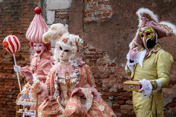 People in costume at the Venice Carnival in front of the Venetian Arsenal.