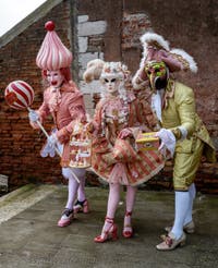 People in costume at the Venice Carnival in front of the Venetian Arsenal.