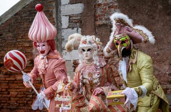 People in costume at the Venice Carnival in front of the Venetian Arsenal.