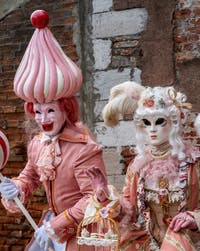 People in costume at the Venice Carnival in front of the Venetian Arsenal.