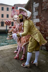 People in costume at the Venice Carnival in front of the Venetian Arsenal.