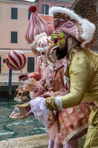 People in costume at the Venice Carnival in front of the Venetian Arsenal.