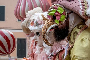 People in costume at the Venice Carnival in front of the Venetian Arsenal.