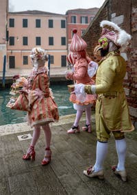 People in costume at the Venice Carnival in front of the Venetian Arsenal.