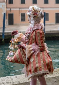 People in costume at the Venice Carnival in front of the Venetian Arsenal.