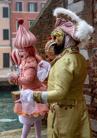 People in costume at the Venice Carnival in front of the Venetian Arsenal.