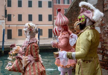 People in costume at the Venice Carnival in front of the Venetian Arsenal.