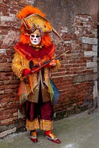 People in costume at the Venice Carnival in front of the Venetian Arsenal.