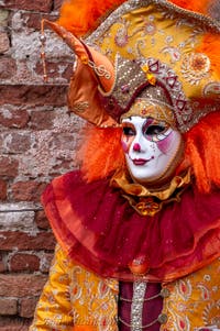 People in costume at the Venice Carnival in front of the Venetian Arsenal.