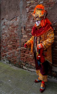 People in costume at the Venice Carnival in front of the Venetian Arsenal.