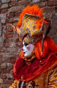 People in costume at the Venice Carnival in front of the Venetian Arsenal.