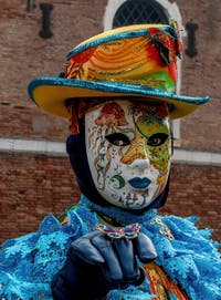 People in costume at the Venice Carnival in front of the Venetian Arsenal.