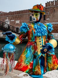 People in costume at the Venice Carnival in front of the Venetian Arsenal.