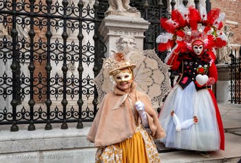 People in costume at the Venice Carnival in front of the Venetian Arsenal.