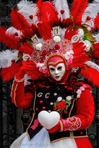 People in costume at the Venice Carnival in front of the Venetian Arsenal.